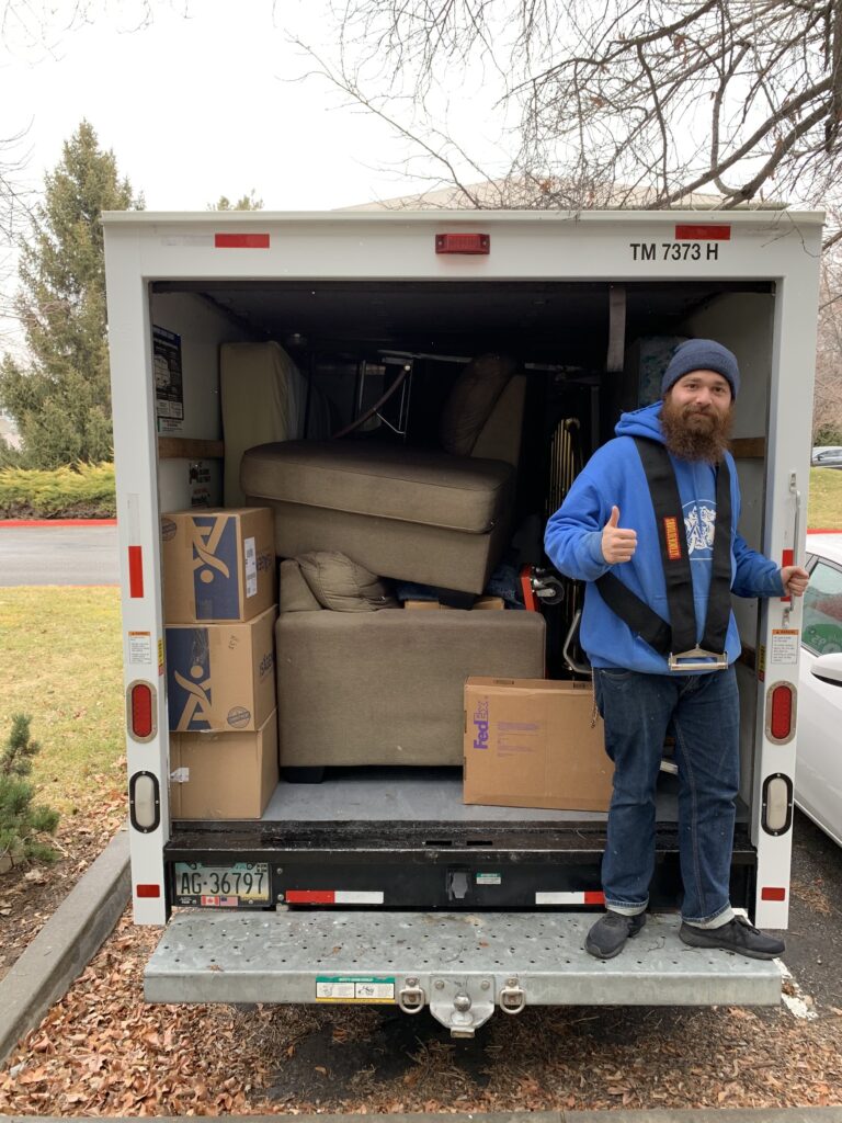 College Movers team member beside a loaded trailer