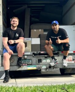 Two College Movers team members working inside a moving truck